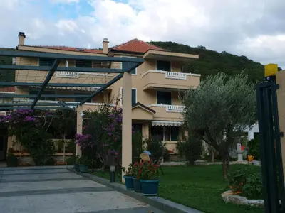 a building with plants and flowers in front of it at Apartments Laništa - Dragović in Petrovac na Moru