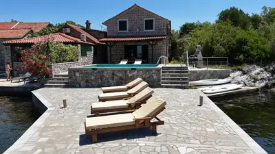 a group of lounge chairs sitting next to a pool at Apartments Kovinic in Tivat
