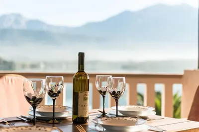 a bottle of wine sitting on a table with wine glasses at Apartments Kovinic in Tivat