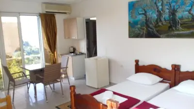 a room with two beds and a kitchen and a table at Cozy studio by the sea in Ulcinj, 35 m² with view in Ulcinj