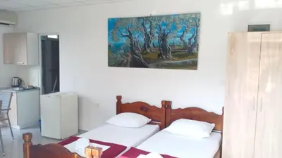 two beds in a room with a painting on the wall at Cozy studio by the sea in Ulcinj, 35 m² with view in Ulcinj