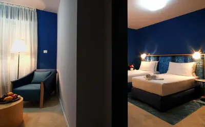 a hotel room with a bed and a chair at Panonija in Kotor