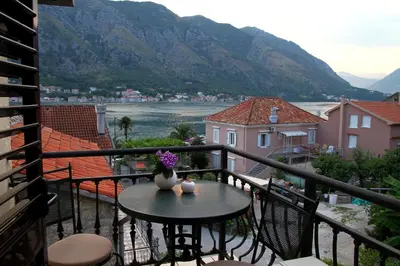 a balcony with a table with a vase of flowers at Panonija in Kotor