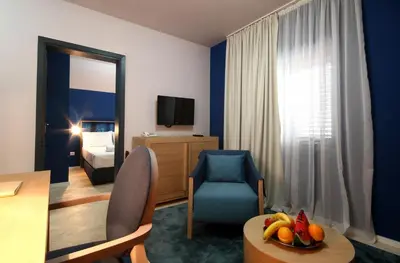 a hotel room with a table and a room at Panonija in Kotor