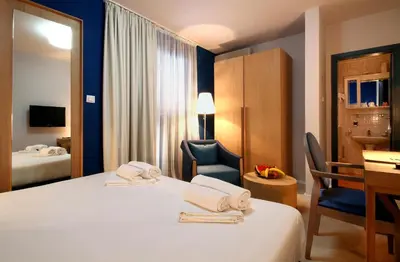 a hotel room with a bed and a chair and a desk at Panonija in Kotor