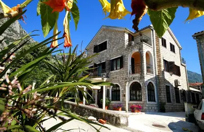 a large stone building with flowers in front of it at Panonija in Kotor