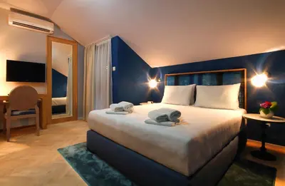 a bedroom with a large bed with two towels on it at Panonija in Kotor