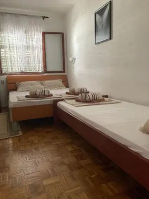 two twin beds in a room with wooden floors at Apartments Aleksic in Sutomore