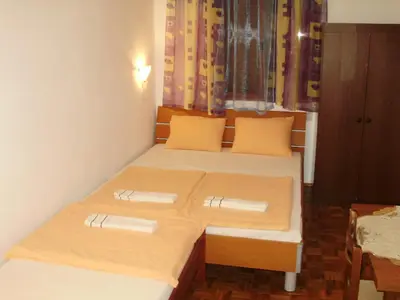 a bedroom with two beds with orange pillows at Apartments Aleksic in Sutomore
