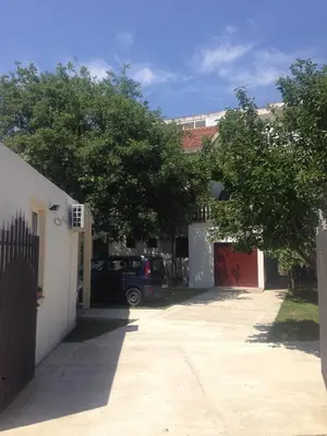 a car parked in a driveway next to a house at Apartments Aleksic in Sutomore