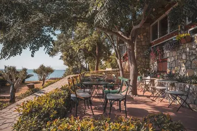 a patio with tables and chairs in front of a building at Hotel R in Utjeha