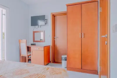 a bedroom with a large wooden closet and a desk at Hotel R in Utjeha