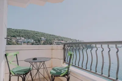a balcony with a table and chairs and the ocean at Hotel R in Utjeha