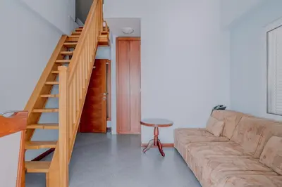 a living room with a couch and a staircase at Hotel R in Utjeha