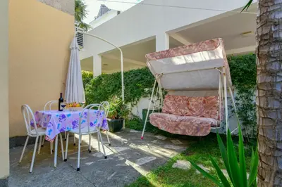 a patio with a table and chairs and an umbrella at Rooms and Apartments Oregon in Budva