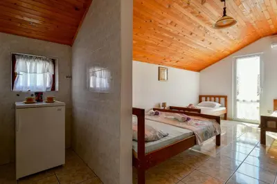a bedroom with a bed and a wooden ceiling at Rooms and Apartments Oregon in Budva