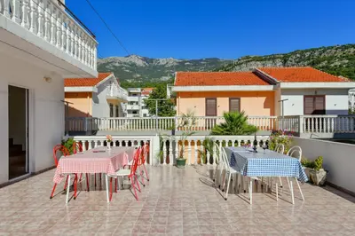 two tables and chairs on the balcony of a house at Rooms and Apartments Oregon in Budva