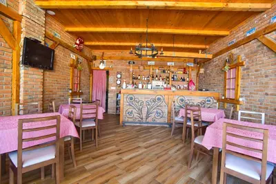 a restaurant with pink tables and chairs and a bar at Apartments Villa Sveti Nikola in Budva