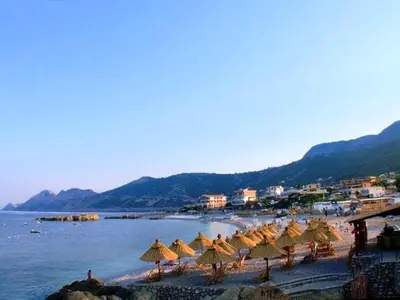 a group of umbrellas on a beach with the water at David apartments and rooms in Dobra Voda