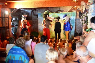 a crowd of people watching a man on a stage at David apartments and rooms in Dobra Voda