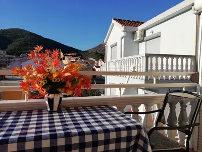 a vase of flowers sitting on a table on a balcony at Apartment White Lily of Budva in Budva