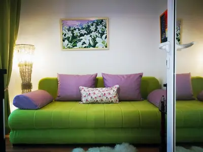 a green couch with pillows in a living room at Apartment White Lily of Budva in Budva