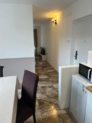 a room with a table and a chair and a microwave at House Pravilovic apartments in Cetinje