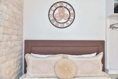 a clock on a wall above a bed with pillows at Old Town Skyline apartment 3 in Budva