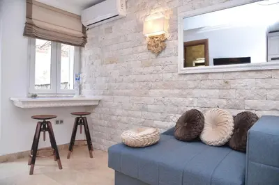 a living room with a blue couch and a brick wall at Old Town Skyline apartment 3 in Budva