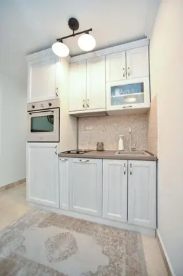 a kitchen with white cabinets and a stove top oven at Old Town Skyline apartment 3 in Budva
