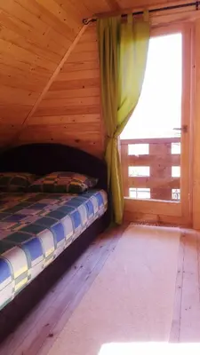 a bed in a wooden room with a window at Brvnara Borovik in Cetinje