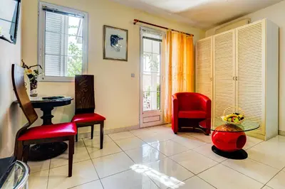 a living room with two red chairs and a table at Sun Rose Apartments Sveti Stefan in Sveti Stefan