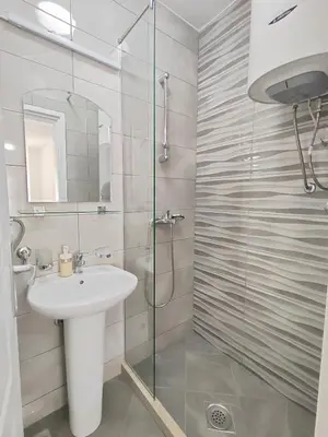 a bathroom with a sink and a glass shower at MM Apartments in Budva