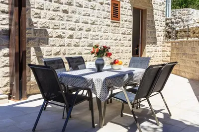 a table with chairs and a blue and white table cloth at Villa Rijeka Rezevici in Petrovac na Moru