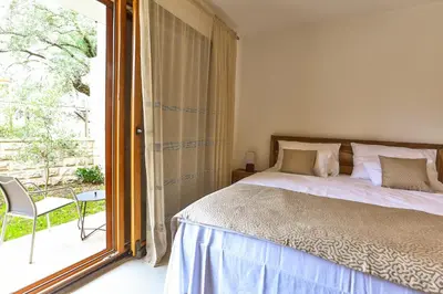 a bedroom with a bed and a large window at Villa Rijeka Rezevici in Petrovac na Moru