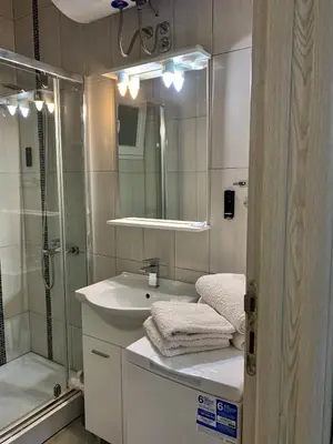 a bathroom with a shower and a sink and a mirror at Apartments MM in Sveti Stefan