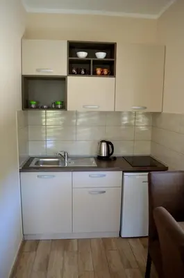 a kitchen with white cabinets and a sink at Apartments MM in Sveti Stefan
