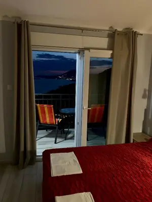 a bedroom with a bed and a view of the ocean at Apartments MM in Sveti Stefan