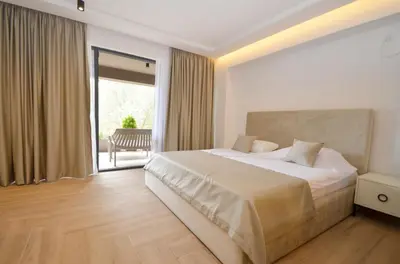 a bedroom with a large bed and a balcony at Royal Olive Residence in Kotor