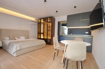 a bedroom with a bed and a table and chairs at Royal Olive Residence in Kotor