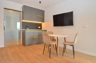 a kitchen and dining room with a table and chairs at Royal Olive Residence in Kotor