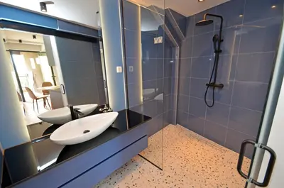 a bathroom with a sink and a shower with a mirror at Royal Olive Residence in Kotor
