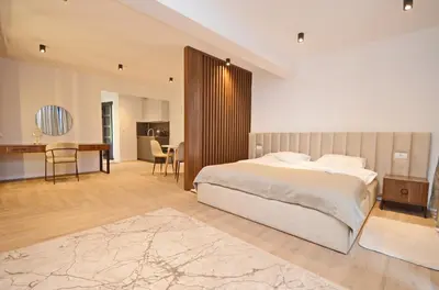 a bedroom with a bed and a table and a desk at Royal Olive Residence in Kotor