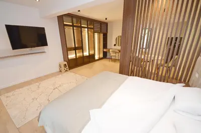 a bedroom with a white bed and a flat screen tv at Royal Olive Residence in Kotor