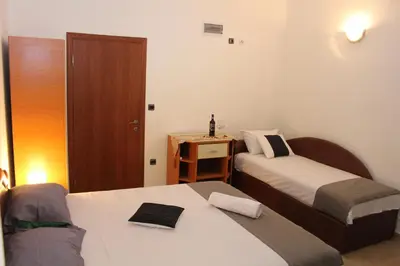 a small room with two beds and a table at Apartments Perezaj II in Ulcinj