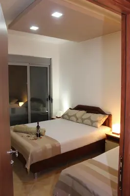 a bedroom with a large bed and a mirror at Apartments Perezaj II in Ulcinj