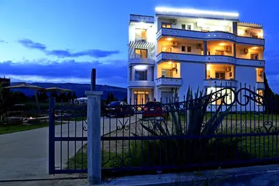 a large white building with a fence in front of it at Apartments Perezaj II in Ulcinj