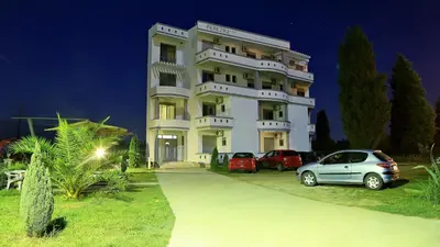 a white building with cars parked in front of it at Apartments Perezaj II in Ulcinj