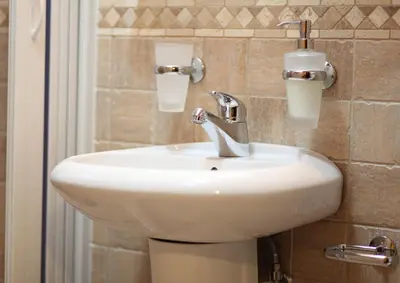 a white sink in a bathroom next to a shower at Hotel Laguna in Podgorica