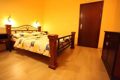 a bedroom with a bed and a wooden floor at Hotel Laguna in Podgorica